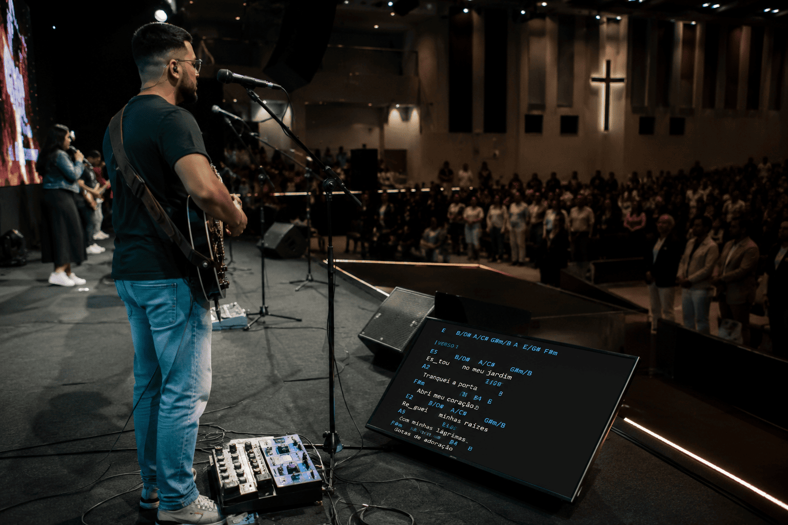 Músico tocando ao vivo com o SmartCifra rodando no retorno de palco